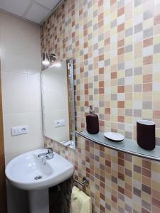 a bathroom with a sink and a mirror at Ático con terrazas en el caso antiguo in Huesca