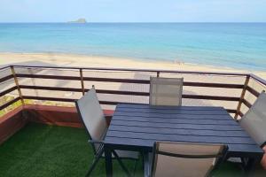 uma mesa e cadeiras numa varanda com praia em Apartamento primera línea La Manga em La Manga del Mar Menor