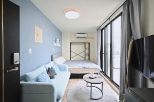 a living room with a couch and a bed at 谷園酒店公寓Good Garden Apartment in Taichung