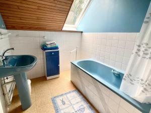 y baño con bañera azul y lavamanos. en TY AR STIVELL, l’équilibre entre terre et mer 4-7 personnes à MOELAN SUR MER, en Moëlan-sur-Mer