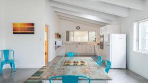 a kitchen with a table and chairs and a refrigerator at Beach Lane in Yamba