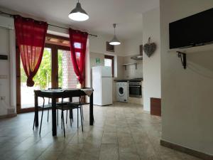 cocina con mesa y cortinas rojas en una habitación en CASALE ANTICO SOBBORGO, en Vitorchiano