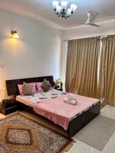 a bedroom with a large bed with a pink blanket at Good Stay Premium Studio Apartment 206 in Dabolim