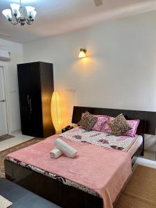 ein Schlafzimmer mit einem großen Bett mit rosa Bettwäsche in der Unterkunft Good Stay Premium Studio Apartment 206 in Dabolim