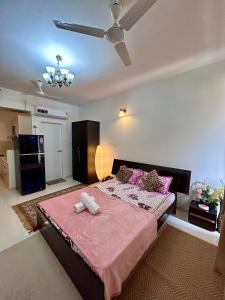 sypialnia z dużym łóżkiem z różową pościelą w obiekcie Good Stay Premium Studio Apartment 206 w mieście Dabolim