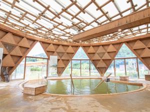 a large room with a pool of water with windows at Kur Park Nagayu in Nitta