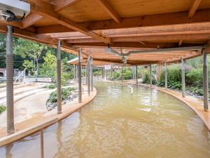 una piscina d'acqua sotto una struttura in legno di Kur Park Nagayu a Nitta