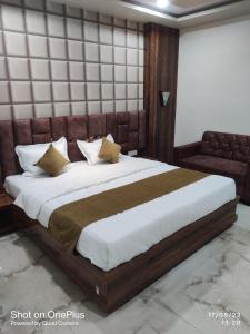 a bedroom with a large bed and a couch at Hotel Praj Paradise in Brahmapur