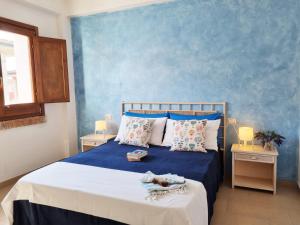 1 dormitorio con 1 cama con pared azul en Barko Apartments & Suites, en Steccato