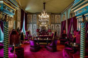 a room with purple chairs and a chandelier at Maison Souquet, Hotel & Spa in Paris