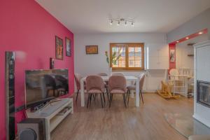 a dining room with a table and a tv at Wellness Chalupa Benešky in Vsetín