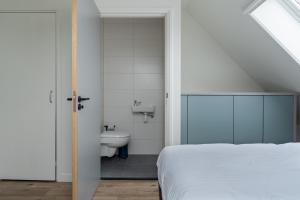 een slaapkamer met een bed, een wastafel en een toilet bij SneekermeerZicht in Offingawier