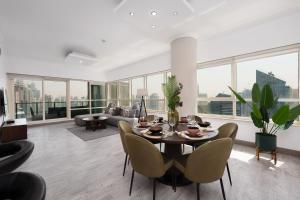 sala de estar con mesa, sillas y sofá en Maison Privee - Dreamy Apt with Jaw-Dropping Marina Views, en Dubái