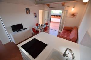 a kitchen with a tv and a living room at Complesso La Foce - Clima, parcheggi, spazi esterni privati in Marina di Campo