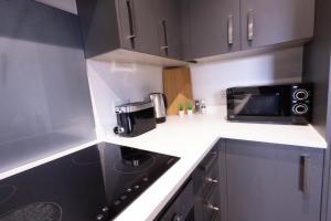 a small kitchen with a microwave and a stove at Chic City Living - Luxury Apartment in London in Hemel Hempstead