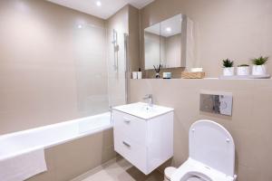 a white bathroom with a toilet and a sink at Chic City Living - Luxury Apartment in London in Hemel Hempstead