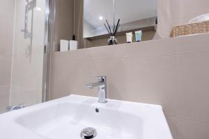 a bathroom with a white sink and a mirror at Chic City Living - Luxury Apartment in London in Hemel Hempstead