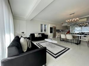 uma sala de estar com um sofá preto e uma mesa em Kaplan Luxury Flat - 3 Bedrooms with air conditioning & heating in the City em Istambul