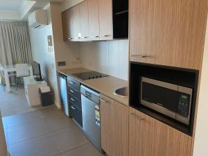 a kitchen with a sink and a microwave at Modern Dual Key Apt w Pool in the heart of Mackay in Mackay