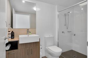 a bathroom with a shower and a toilet and a sink at Modern Dual Key Apt w Pool in the heart of Mackay in Mackay