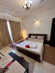 sypialnia z 2 łóżkami i żyrandolem w obiekcie Good Stay Studio Apartment 307 w mieście Dabolim
