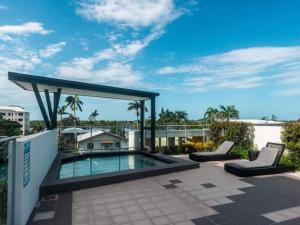 a patio with a swimming pool and two lounge chairs at Modern Dual Key Apt w Pool in the heart of Mackay in Mackay