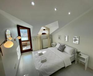 ein weißes Schlafzimmer mit einem Bett und einem Spiegel in der Unterkunft Kaplan Luxury Flat - 3 Bedrooms with air conditioning & heating in the City in Istanbul