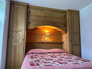 a bedroom with a bed with a wooden headboard at Agriturismo Meizoun Blancho in Fenestrelle