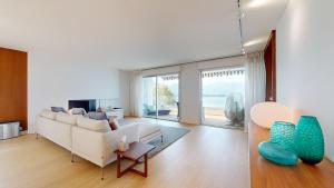 a living room with a white couch and a large window at Lakefront apartment with exceptional view in Territet