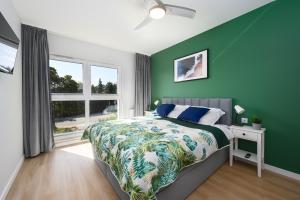 a green bedroom with a bed and a window at Apartament Baltic Breeze ProstyWynajem Gdańsk Brzeźno in Gdańsk