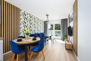 ein Esszimmer mit einem Tisch und blauen Stühlen in der Unterkunft Apartament Baltic Breeze ProstyWynajem Gdańsk Brzeźno in Danzig