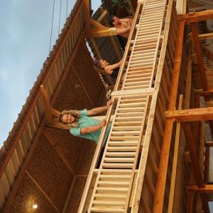 a group of people on a wooden platform in a building at Boneputeh Homestay in Taliwang