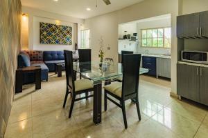 cocina y sala de estar con mesa de cristal y sillas en Hotel Suites Paraíso, en Mérida