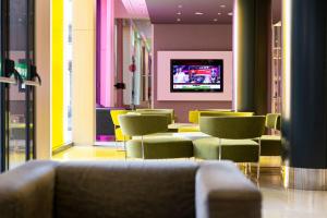 DoubleTree by Hilton Girona في جيرونا: غرفة بها كراسي وطاولة وتلفزيون