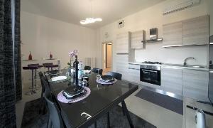 a kitchen with a table and chairs in a room at Triumvirato Rooms in Bologna