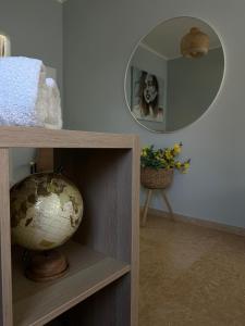a room with a globe on a shelf and a mirror at Pearl of the sea in H̱adera
