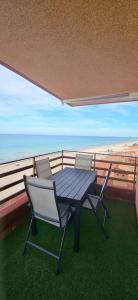 - Balcón con mesa y sillas y vistas a la playa en Apartamento primera línea La Manga, en La Manga del Mar Menor