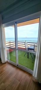 um quarto com uma porta de vidro deslizante e vista para o oceano em Apartamento primera línea La Manga em La Manga del Mar Menor