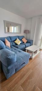 a blue couch in a living room with a table at Apartamento primera línea La Manga in La Manga del Mar Menor