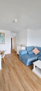 sala de estar con sofá azul y mesa en Apartamento primera línea La Manga, en La Manga del Mar Menor