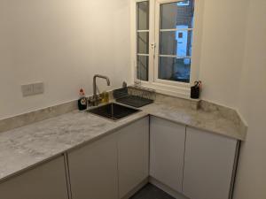 a kitchen counter with a sink and a window at Lovey Stable mews in hidden location in Royal Tunbridge Wells