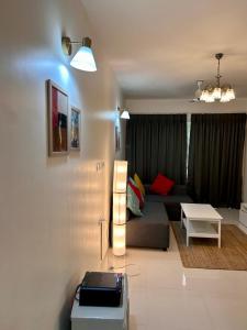 a living room with a couch and a table at Pool And Garden View Good Stay Premium 2 BHK Flat 104 in Dabolim
