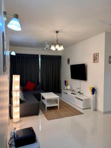 a living room with a couch and a tv at Pool And Garden View Good Stay Premium 2 BHK Flat 104 in Dabolim