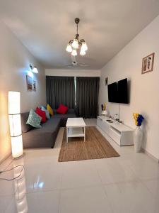 a living room with a couch and a tv at Pool And Garden View Good Stay Premium 2 BHK Flat 104 in Dabolim