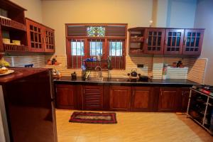 une cuisine avec des armoires en bois et un évier dans l'établissement Lucky cottage, à Habaraduwa Central 24 autres photos