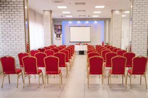 una sala de conferencias con sillas rojas y una mesa con una pizarra en Hotel Slavija, en Belgrado