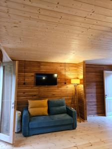- un canapé bleu dans une chambre dotée d'un mur en bois dans l'établissement inSxvava, à Ambrolaouri