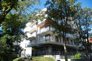 an apartment building with balconies and trees at Apartamenty Feniks in Świnoujście