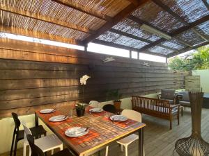 comedor con mesa, sillas y techo en Villa Albizia 974 avec piscine et spa, en Saint-Pierre