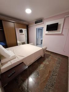 a bedroom with a bed and a tv on the wall at Pandolfo Locações - Casa Foz Oficial in Foz do Iguaçu